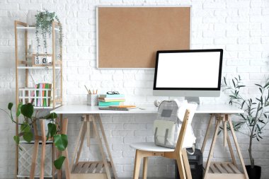 Sırt çantalı sandalye ve çocuk odasındaki boş bilgisayar monitörü.