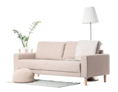 Modern bej kanepe, puf ve zemin lambası beyaz arka planda izole edilmiş.