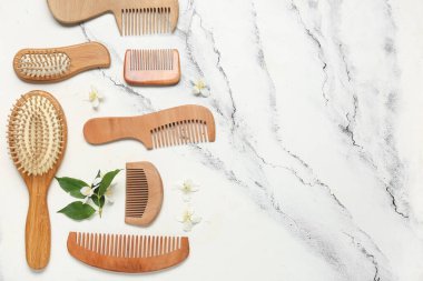 Farklı ahşap saç fırçaları ve hafif arka planda tarakları olan kompozisyon
