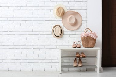 Koridorun iç tarafındaki bankta pembe ortanca çiçekleri olan çanta.