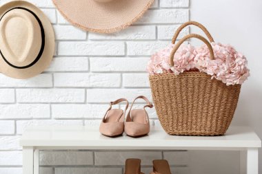 Koridordaki bankta pembe ortanca çiçekli çanta.