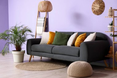 Koltuğu, merdiveni ve palmiyesi olan şık bir oturma odası.