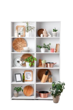 Mutfak gereçleri ve beyaz arka planda bitkileri olan raf ünitesi