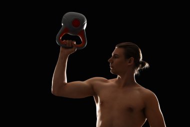 Siyah arka planda kettlebell olan kaslı bir adamın silueti.