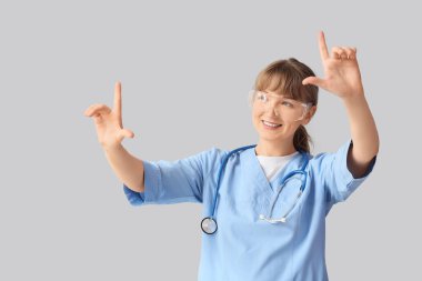 AR gözlüklü kadın doktor, arka planda sanal ekran kullanıyor.