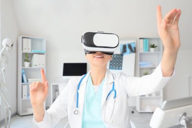 VR gözlüklü kadın doktor hastanede sanal ekran kullanıyor.