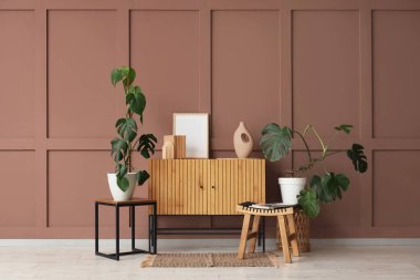 Monstera bitkileri, klozet ve masalarla dolu bir oturma odası.