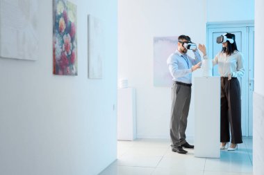 Sanat galerisindeki serginin yakınında VR gözlüklü genç bir çift.