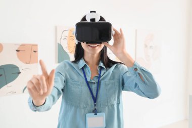 Sanat galerisinde VR gözlük kullanan genç bir kadın.