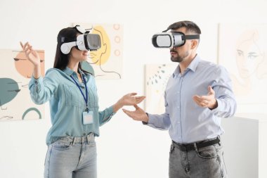 Sanat galerisinde VR gözlük kullanan genç bir çift.
