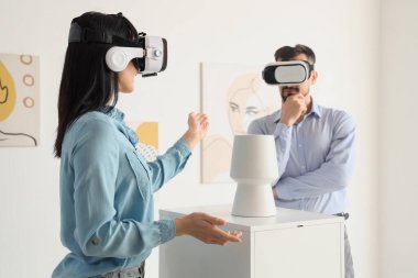 Sanat galerisindeki serginin yakınında VR gözlüklü genç bir çift.