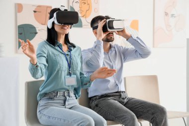 Sanat galerisinde VR gözlük kullanan genç bir çift.