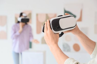 Sanat galerisinde VR gözlüklü erkek eller, yakın plan.