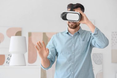 Modern sanat galerisinde VR gözlük kullanan genç adam.