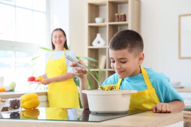 Erişte çorbası ve annesi mutfakta olan tatlı çocuk.