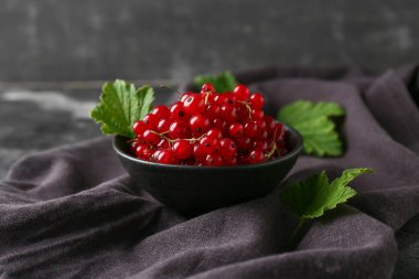 Siyah grunge arka planında taze kırmızı üzümlü kase, yakın plan.