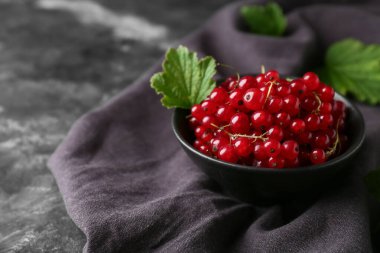 Siyah grunge arka planında taze kırmızı üzümlü kase, yakın plan.