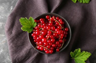 Siyah grunge arka planında taze kırmızı üzümlü kase, yakın plan.