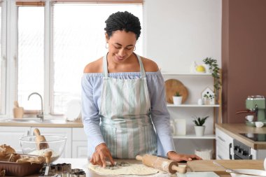 Genç Afro-Amerikalı kadın mutfakta kurabiye yapıyor.