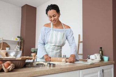 Genç Afro-Amerikalı kadın mutfakta kurabiye için para dağıtıyor.