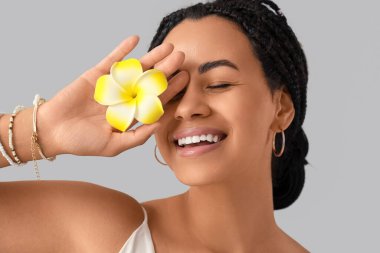 Güzel Afro-Amerikalı kadın. Arka planda hafif çiçekli. Yakın plan.