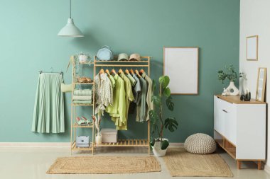 Askısı, aksesuarı ve bitkileri olan bir giyim mağazası.