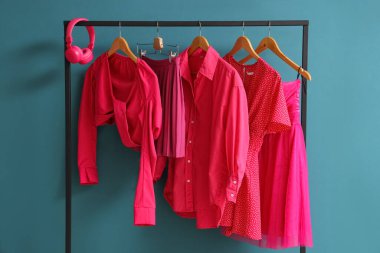 Parlak pembe giysiler ve mavi arka planda kulaklıklar.