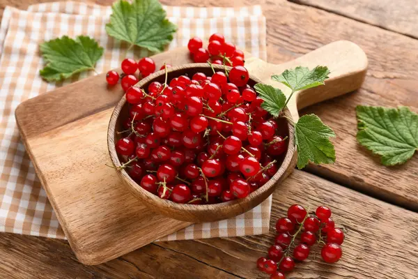 Taze üzümlü kase ve ahşap arka planda yapraklar, yakın plan.