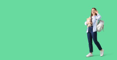 Sırt çantası ve yeşil arkaplan kitapları olan ve metin için yeri olan kız öğrenci