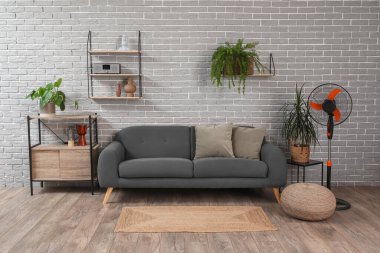 Kanepesi ve elektrikli vantilatörü olan modern oturma odasının içinde.