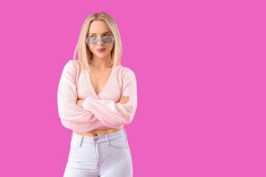 Mor arka planda şık güneş gözlüklü düşünceli genç bir kadın.