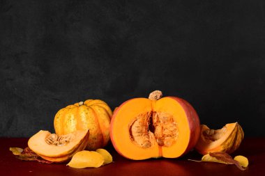 Taze balkabakları ve sonbahar yaprakları kırmızı masada.