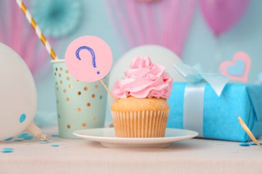 Hediye kutusu ve masasında mavi arka planda süslemeleri olan enfes bir kek. Cinsiyet ortaya çıkan parti kavramı