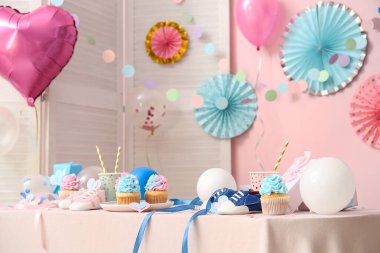 Bebek poposu ve masa üzerinde pembe arka planda süslemeleri olan enfes kekler. Cinsiyet ortaya çıkan parti kavramı