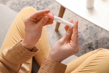 Evinde hamilelik testi olan bir kadın.