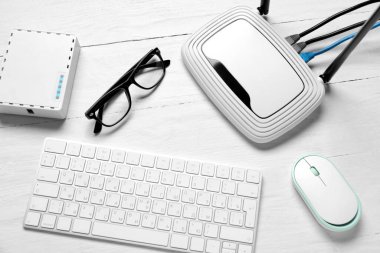 Beyaz ahşap zemin üzerinde modern wi-fi yönlendirici ve klavye