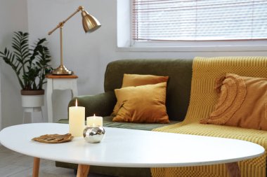 Şık oturma odasındaki masada mum yakmak.