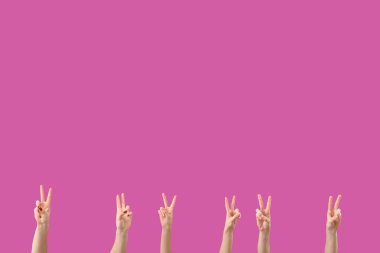 Mor arka planda barış jestleri gösteren kadın elleri