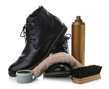 Beyaz arka planda fırça, bot, temizlik spreyi ve ayakkabı cilası izole edilmiş.