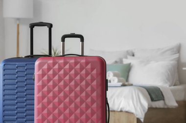 Yatağın yanındaki küçük otel odasında bavullar, yakın plan.