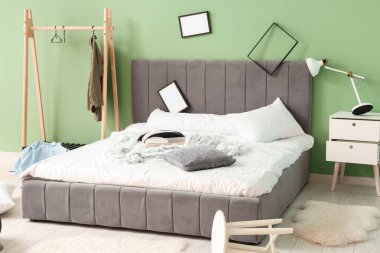 Çerçeveli ve elbise askılı dağınık bir yatak odası.