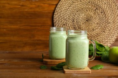 Ahşap arka planda taze ıspanaklı meşrubat kavanozları