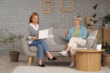 Üzgün genç kız ofiste psikologla konuşuyor.