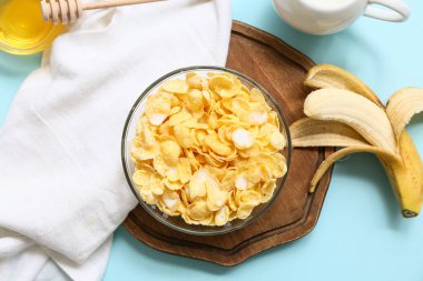 Peçete, muz, mısır gevreği ve sütle kaplanmış kase, yakın plan.