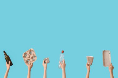 Mavi arka planda farklı çöpleri tutan kadın elleri. Geri dönüşüm kavramı