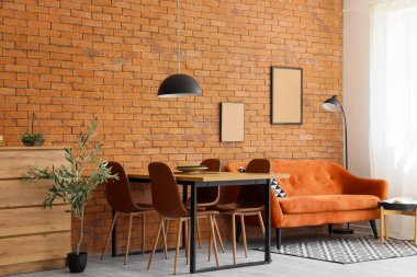 Işıl ışıl bir yemek odası, rahat bir kanepe ve çekmeceleri var.