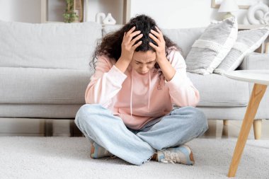 Genç Afro-Amerikalı kadın evde panik atak geçiriyor.