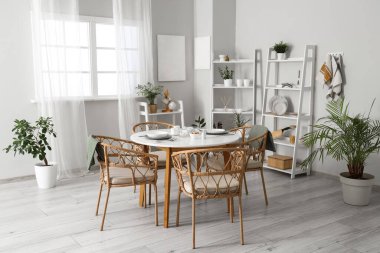 Hasır sandalyeli yemek masası ve şık mutfak odasındaki raf üniteleri.