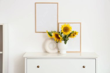 Oturma odasında klozet çerçeveli ayçiçeği vazosu.