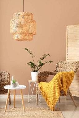 Rahat hasır koltukları ve kahverengi duvarın yanında kahve masası olan modern bir oda.